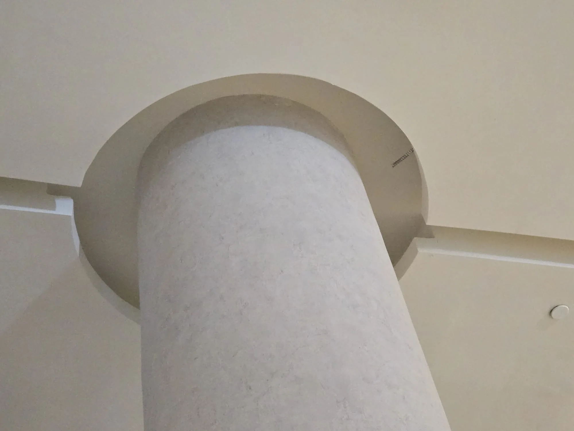 Finished curved column wrap meeting a circular ceiling reveal