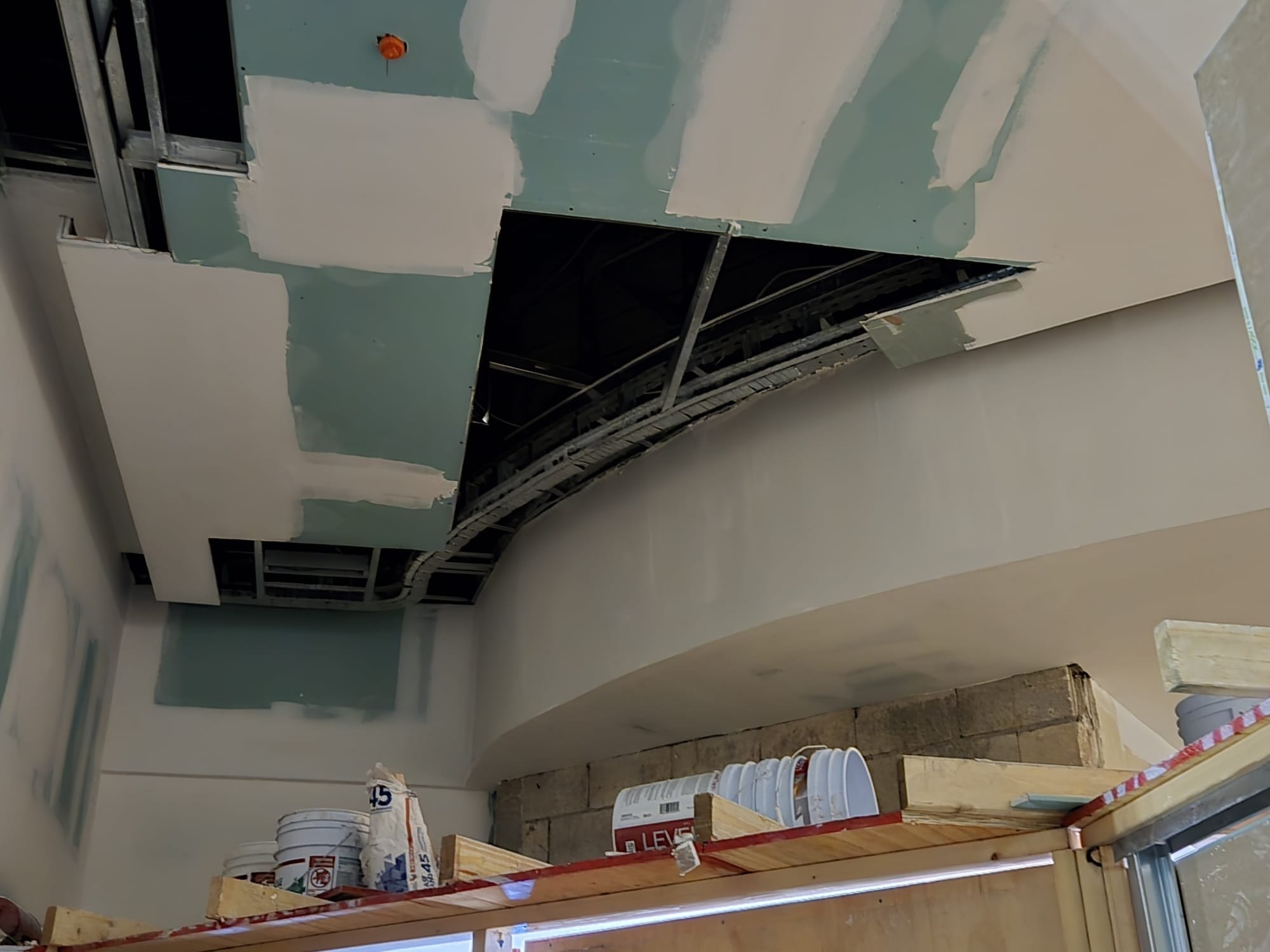 Curved ceiling cove under construction above a service counter