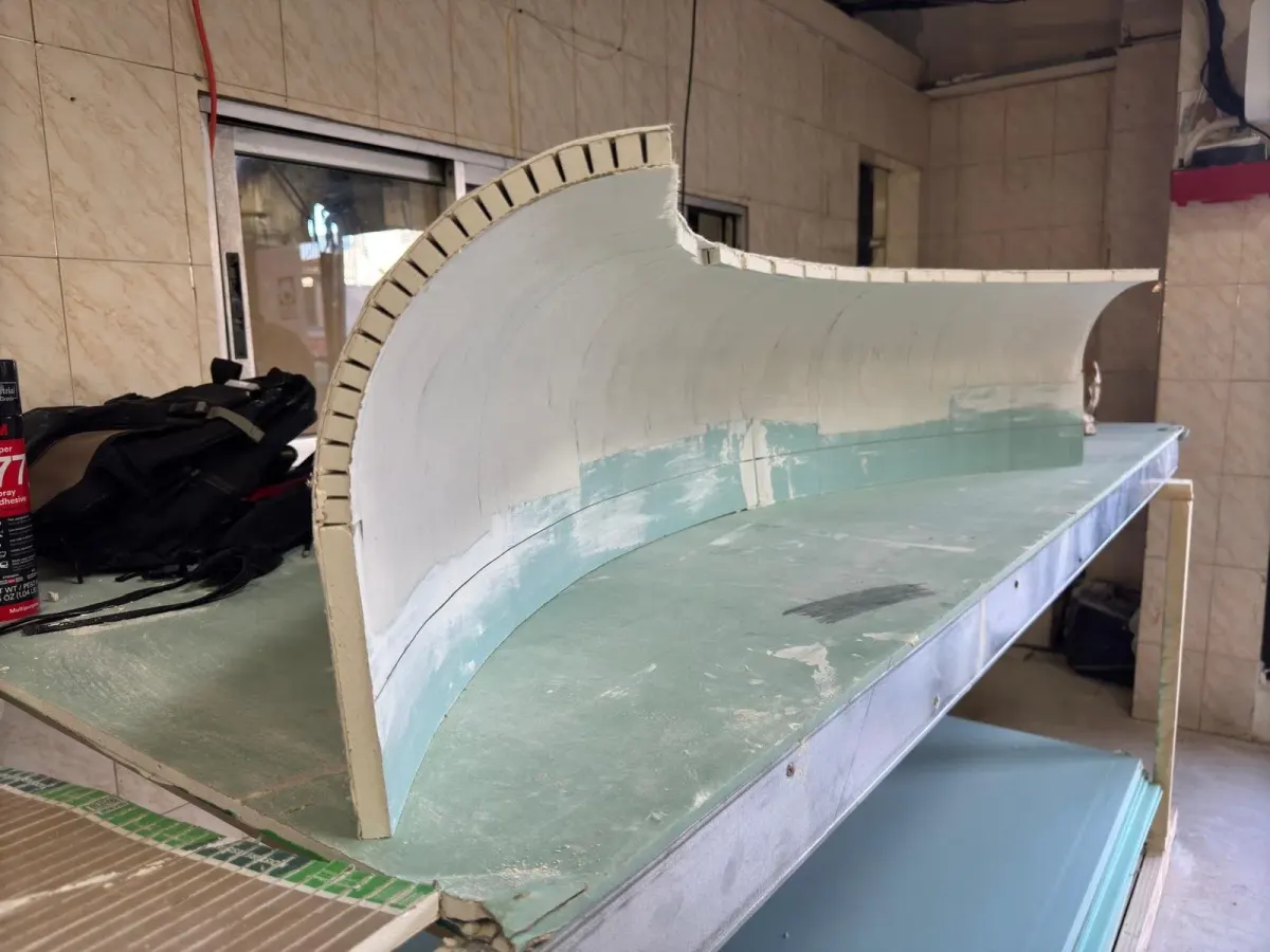 Curved composite cove segment on a workshop table before installation